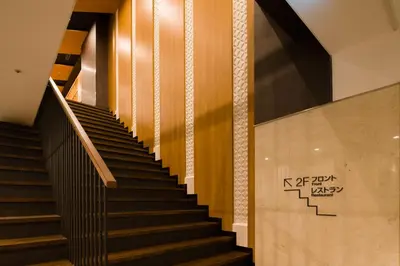 a staircase in a building with a sign on the wall at Tosei Hotel Cocone Ueno in Tokyo