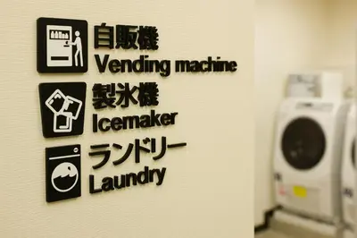a wall with signs on the wall of a bathroom at Tosei Hotel Cocone Ueno in Tokyo