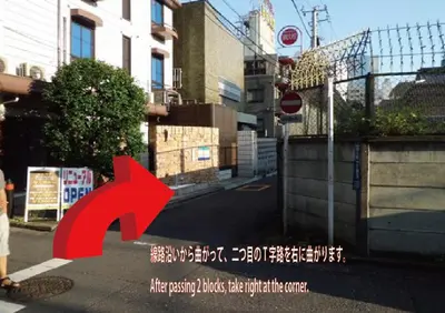 a red arrow on a city street with a building at The Shin-Okubo International Hotel in Tokyo