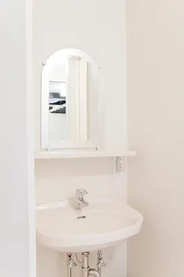 a bathroom with a white sink and a mirror at The Shin-Okubo International Hotel in Tokyo