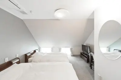a bedroom with two beds and a tv at The Shin-Okubo International Hotel in Tokyo