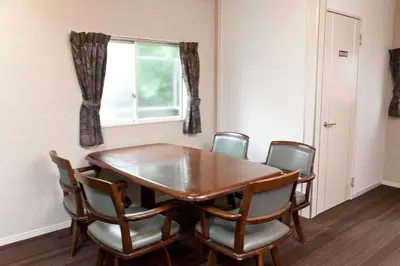 a dining room table with chairs and a window at The Shin-Okubo International Hotel in Tokyo