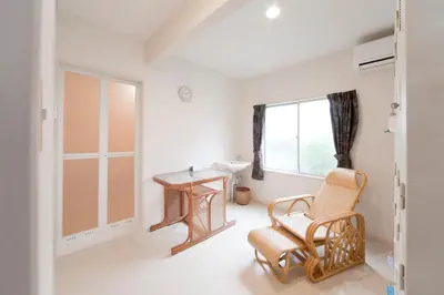 a room with a chair and a table and a window at The Shin-Okubo International Hotel in Tokyo