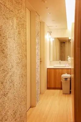 a bathroom with a sink and a toilet and a mirror at Hotel Comfact in Tokyo