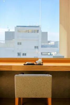 a wooden table with a view of a large window at Hotel Comfact in Tokyo