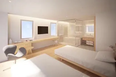 a large white room with a bed and a desk at Hotel Comfact in Tokyo
