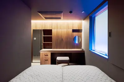 a bedroom with a white bed and a window at Hotel Comfact in Tokyo
