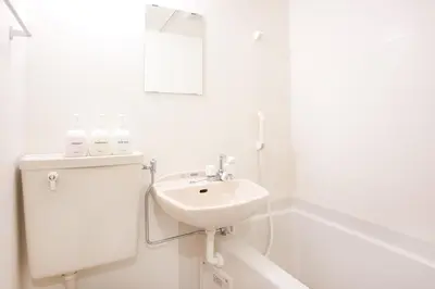 a white bathroom with a sink and a mirror at Hanabi Hotel in Tokyo