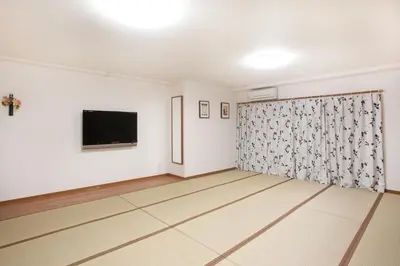 an empty room with white walls and a flat screen tv at Hanabi Hotel in Tokyo