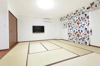 an empty room with a television and a white floor at Hanabi Hotel in Tokyo