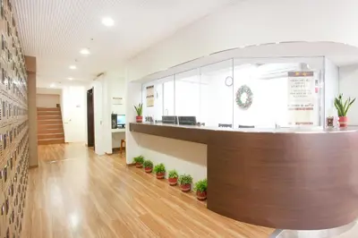 an office lobby with a counter and potted plants at Hanabi Hotel in Tokyo