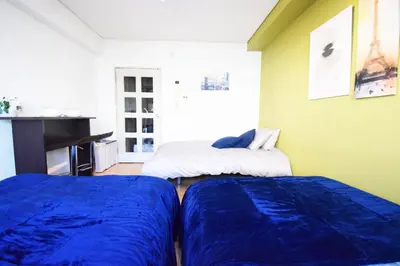a bedroom with two beds and a piano at LIONS APARTMENT 516 in Tokyo