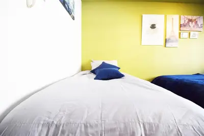 a bed with a blue pillow on it in a room at LIONS APARTMENT 516 in Tokyo