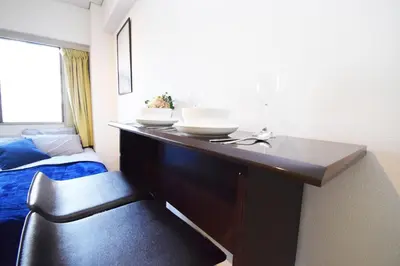 a bedroom with a desk and a chair and a bed at LIONS APARTMENT 516 in Tokyo