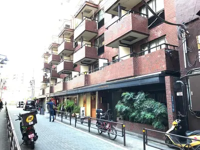 a motorcycle parked on a sidewalk in front of a building at LIONS APARTMENT 516 in Tokyo