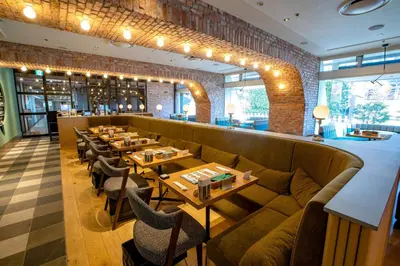 a restaurant with a long couch and tables and chairs at Shinagawa Prince Hotel East Tower in Tokyo