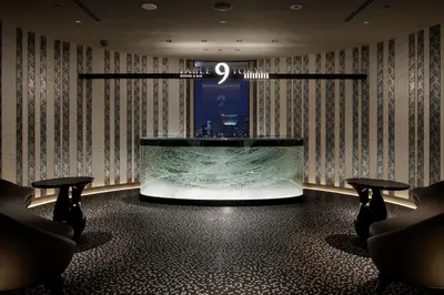 a lobby with a large aquarium in the middle of a room at Shinagawa Prince Hotel East Tower in Tokyo