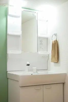 a white bathroom with a sink and a mirror at Blue Empire Hotel in Tokyo