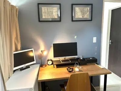 a desk with two computer monitors on top of it at COCO Shinjuku HOTEL in Tokyo