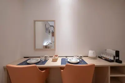 a dining room table with two chairs and a mirror at Studio Inn Nishi Shinjuku in Tokyo