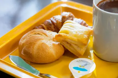 a tray with a plate of pastries and a cup of coffee at KOKO HOTEL Shimbashi Onarimon - formerly Hotel Wing International Shimbashi Onarimon in Tokyo