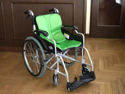 a green wheelchair sitting on a wooden floor at KOKO HOTEL Ikebukuro - formerly Hotel Wing International Select Ikebukuro in Tokyo