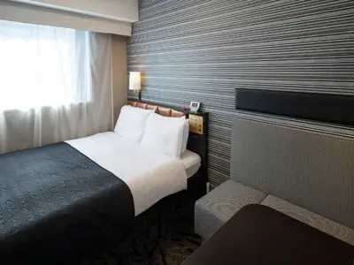 a hotel room with a bed and a window at APA Hotel Mita Ekimae in Tokyo