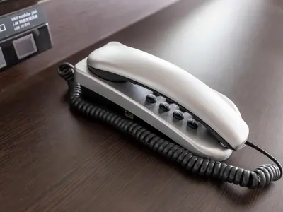 a white phone sitting on a wooden table at APA Hotel Mita Ekimae in Tokyo
