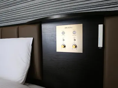 a bed with a black headboard with a white pillow at APA Hotel Higashi Shinjuku Ekimae in Tokyo