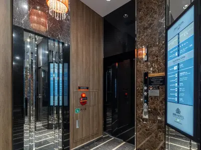a elevator in a building with a sign on the wall at APA Hotel Higashi Shinjuku Ekimae in Tokyo