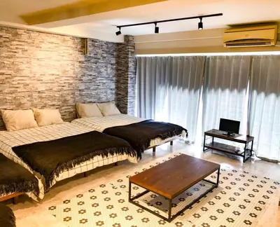 a bedroom with two beds and a brick wall at Yoyogi Apartment 2-301 by Tranova in Tokyo