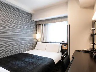 a hotel room with a bed and a window at APA Hotel Shibuya Dogenzakaue in Tokyo