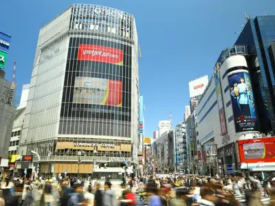 a crowd of people crossing a busy city street at APA Hotel Shibuya Dogenzakaue in Tokyo