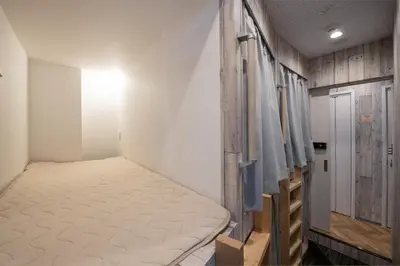 a small bedroom with a bed and a closet at bnb+ Kanda Terrace Ogawamachi in Tokyo