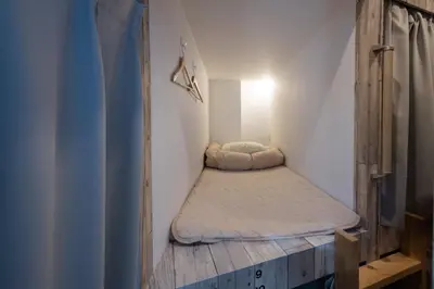 a small room with a bed in the corner at bnb+ Kanda Terrace Ogawamachi in Tokyo