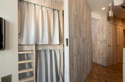 a room with a curtain and a door with a window at bnb+ Kanda Terrace Ogawamachi in Tokyo