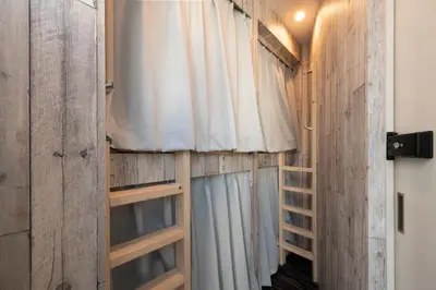 a room with wooden walls and curtains and a window at bnb+ Kanda Terrace Ogawamachi in Tokyo