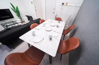 a white table with chairs and cups and plates on it at FINOA Residential Suite IKEBUKURO - 5BR Large Vacation Home in Tokyo