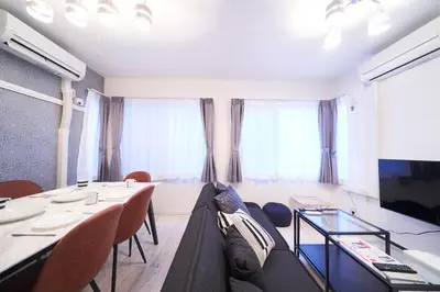 a living room with a table and chairs and a tv at FINOA Residential Suite IKEBUKURO - 5BR Large Vacation Home in Tokyo