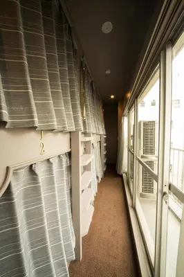 an empty train hallway with blinds on the windows at THE WARDROBE Hotel Shimokitazawa in Tokyo