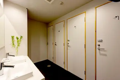 a bathroom with a sink and four lockers at plat hostel keikyu minowa forest in Tokyo