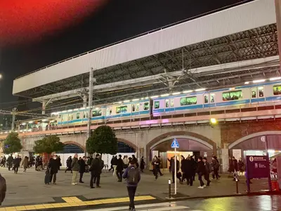 a crowd of people walking near a train station at night at Hotel Owl Tokyo Shinbashi in Tokyo