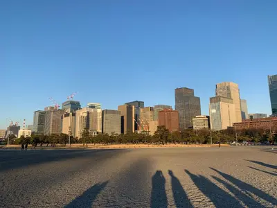 two shadows of people on a street in front of a city at Hotel Owl Tokyo Shinbashi in Tokyo