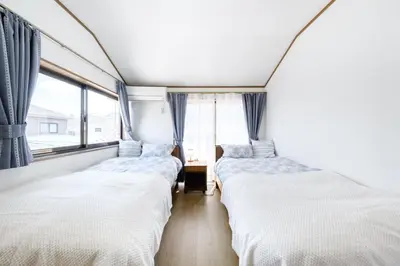 two beds in a room with a window at \u6771\u4eac\u82b3\u534e\u9a7f\u7ad9 in Tokyo