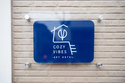 a blue sign on the wall of a building at Cozy Vibes Apt Hotel in Tokyo