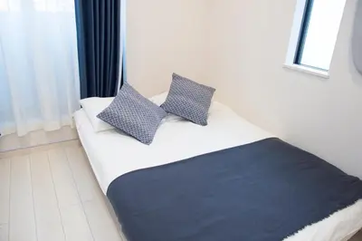 a bed with two pillows on it in a room at Cozy Vibes Apt Hotel in Tokyo