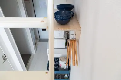a small wooden shelf with a blue bowl on it at Cozy Vibes Apt Hotel in Tokyo