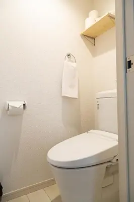 a bathroom with a toilet and a towel on the wall at Cozy Vibes Apt Hotel in Tokyo