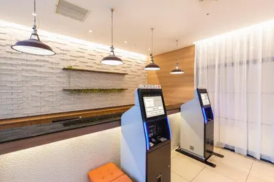 an atm machine in a lobby with pendant lights at Sotetsu Fresa Inn Tokyo-Toyocho in Tokyo