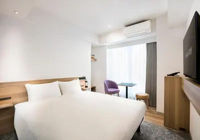 a hotel room with a white bed and a tv at Tokyu Stay Shibuya Shin-Minamiguchi in Tokyo